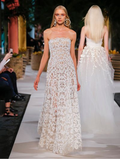 A model wears a white lace gown