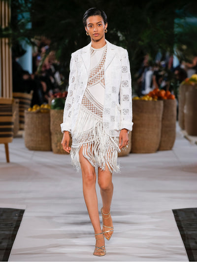 A model wears a white lace dress with matching blazer